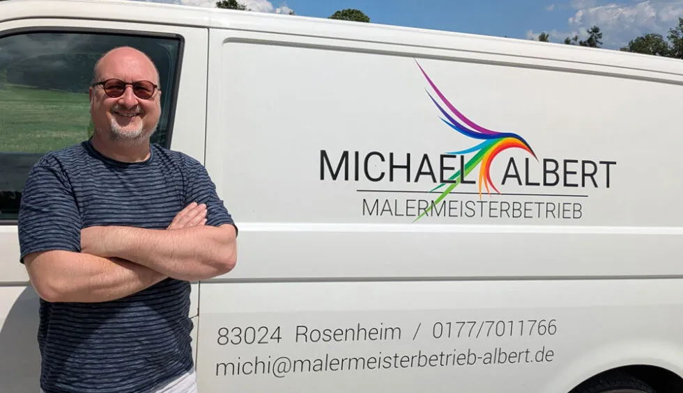 Michael Albert vor seinem Firmenwagen mit dem Logo des Malermeisterbetriebs